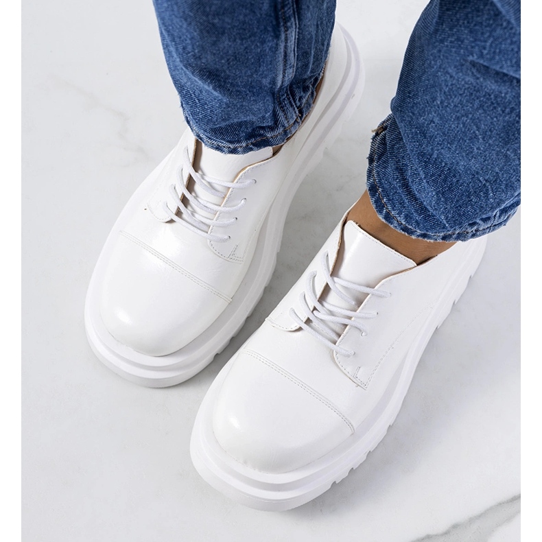 Sapatos brancos em uma sola de trator de Henta 1