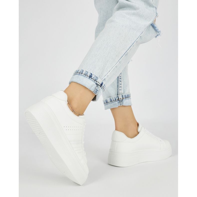 Tênis esportivos brancos na plataforma 2