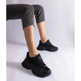 Tênis esportivos negros em uma sola enorme preto 1