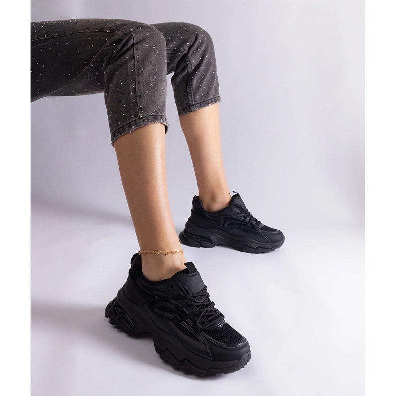 Tênis esportivos negros em uma sola enorme preto 1