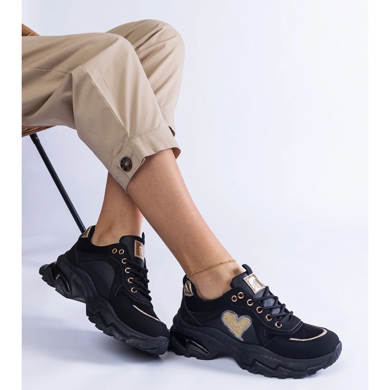 Tênis pretos em uma plataforma de coração preto 1