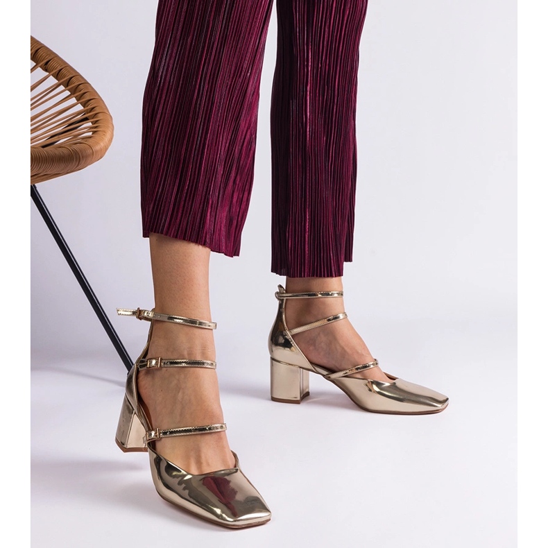 Bombas douradas envernizadas em um post com fivelas dourado 1