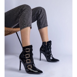 Botas pretas envernizadas em um salto alto com fivela preto 1