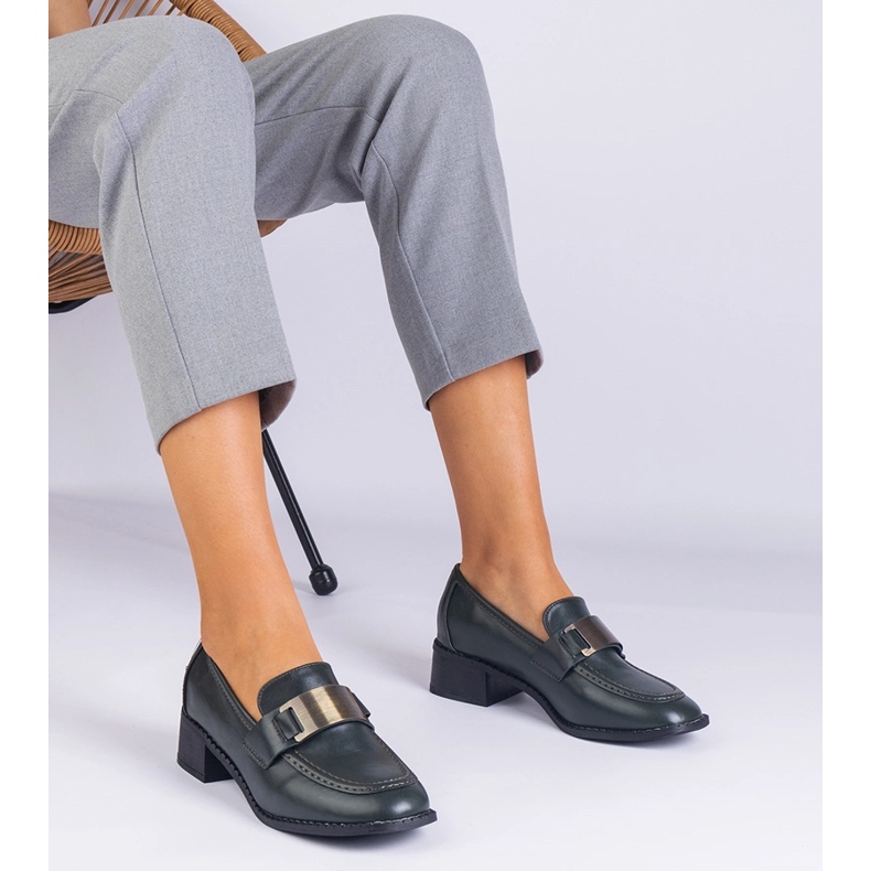 Sapatos verdes em um post baixo com uma decoração metálica 1