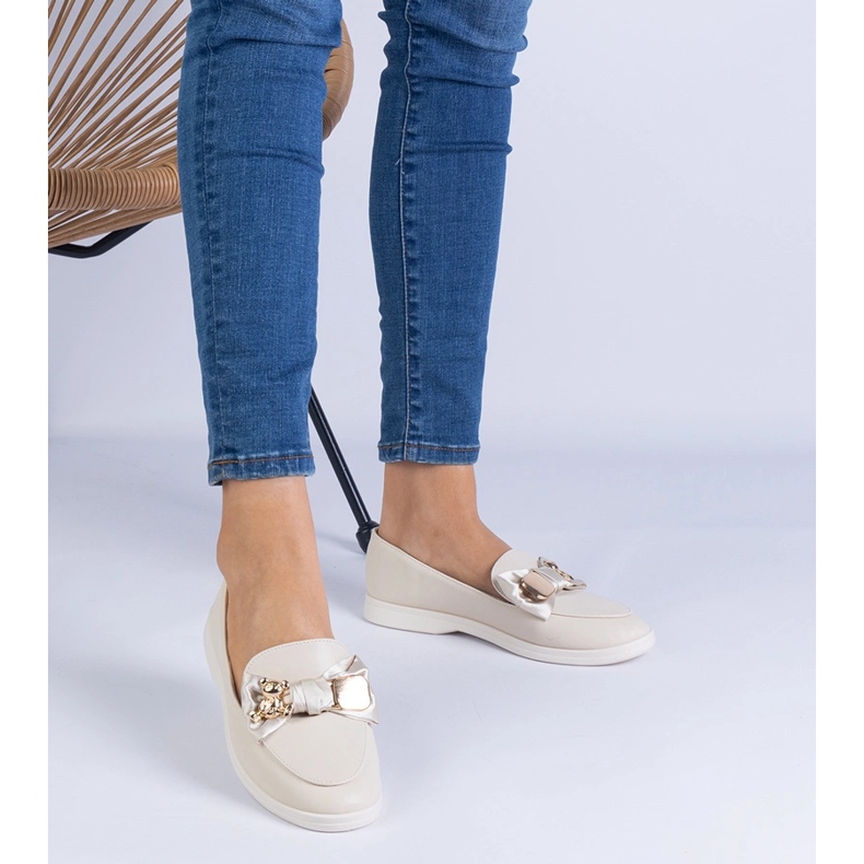 Mocas bege decorados com um arco e um ursinho de pelúcia dourado 1