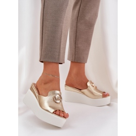 Slippers na plataforma e cunhas com um ornamento dourado 2