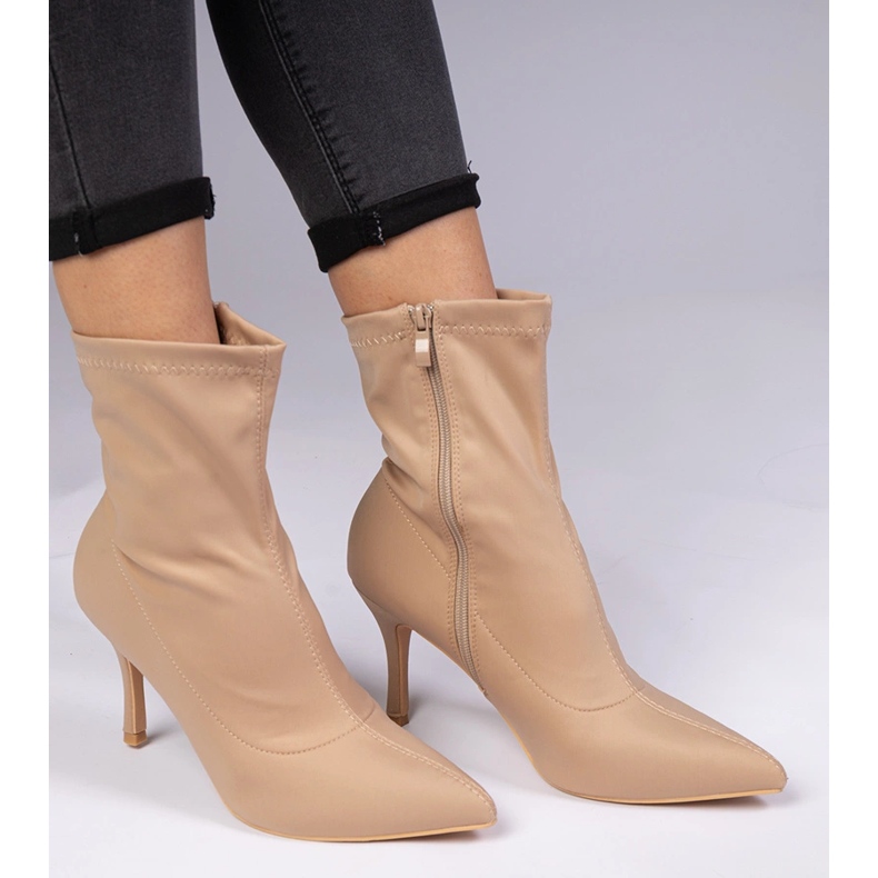 Botas bege com um acabamento acetinado em um alfinete 1 Botas bege com um acabamento acetinado em um alfinete 1