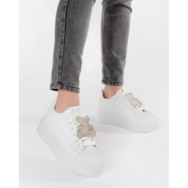 Tênis brancos em uma plataforma de ursinho de pelúcia 2