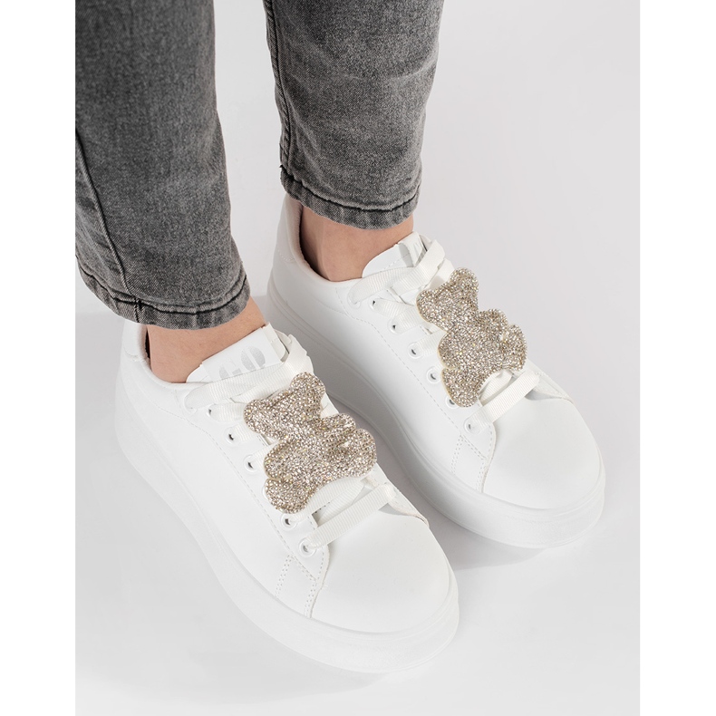 Tênis brancos em uma plataforma de ursinho de pelúcia 1