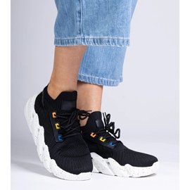 Tênis esportivos negros em uma sola enorme preto 1