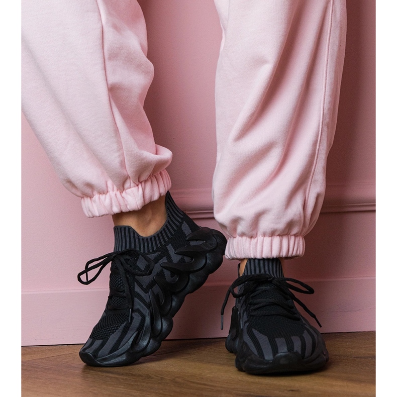 Tênis esportivos negros em uma sola enorme preto 1