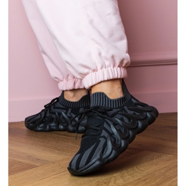 Tênis esportivos negros em uma sola enorme preto 2