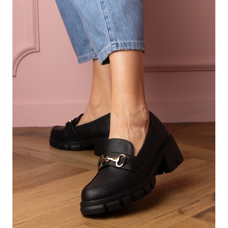 Sapatos pretos em um post baixo com uma decoração de ouro 1