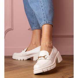 Sapatos brancos em um post baixo com um ornamento dourado 1