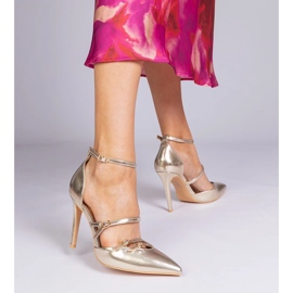 Bombas douradas em um salto alto preso ao redor do tornozelo dourado 1