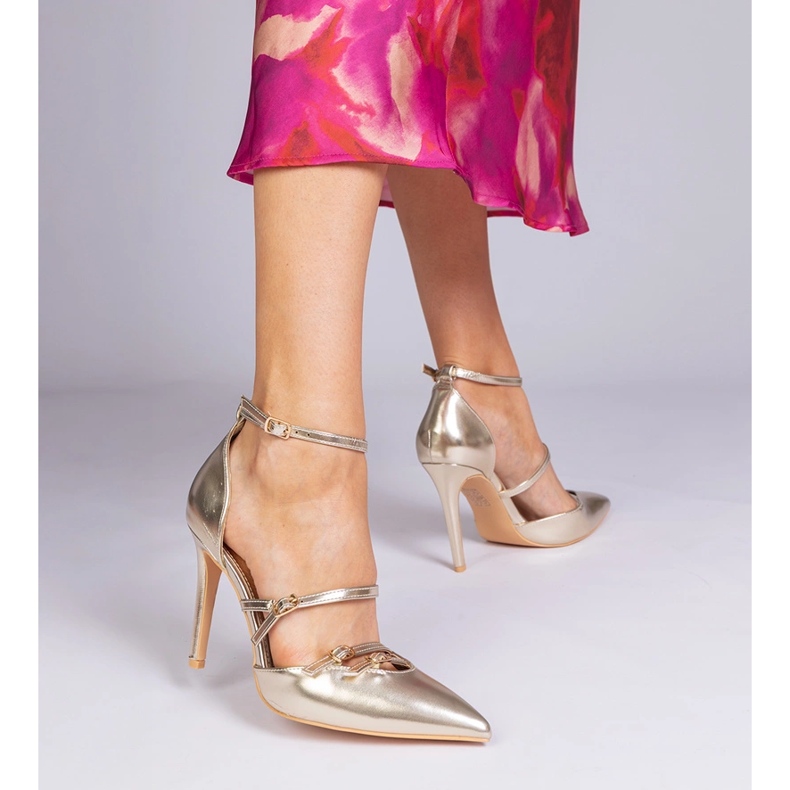 Bombas douradas em um salto alto preso ao redor do tornozelo dourado 1