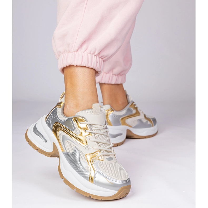 Tênis de esportes dourados em uma sola grossa 1