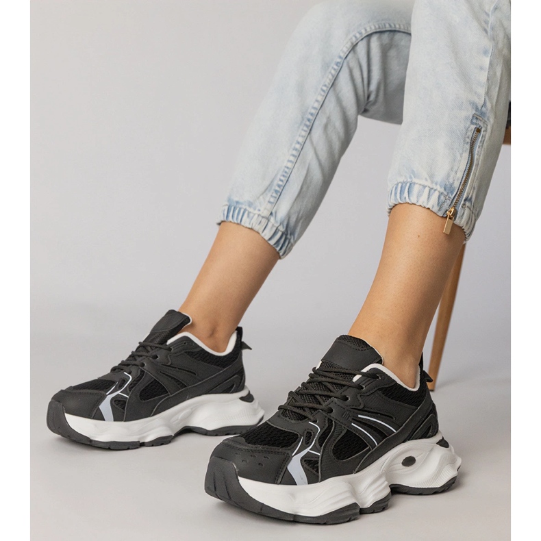 Tênis esportivos negros em uma sola enorme preto 1