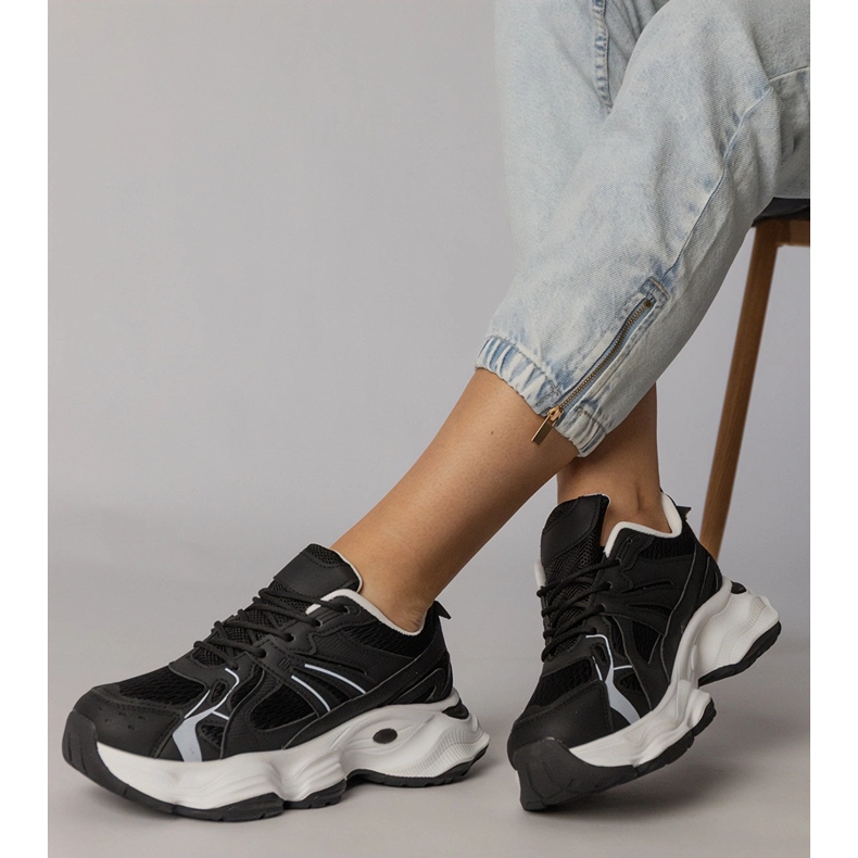 Tênis esportivos negros em uma sola enorme preto 2