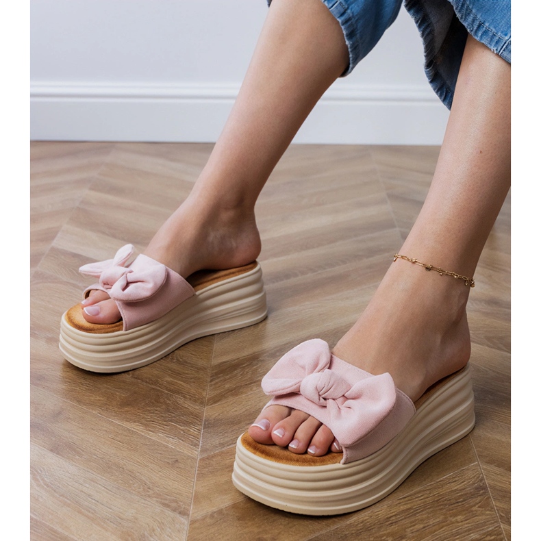 Chinelos cor de rosa na plataforma com um laço 1