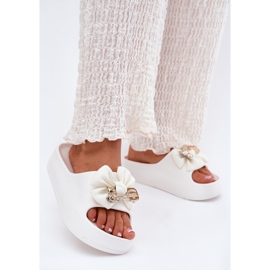 Chinelos de espuma feminina na plataforma com um arco e um broche branco 2 Chinelos de espuma feminina na plataforma com um arco e um broche branco 2