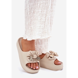 Flip de espuma feminina na plataforma com um arco e um broche bege escuro 1 Flip de espuma feminina na plataforma com um arco e um broche bege escuro 1
