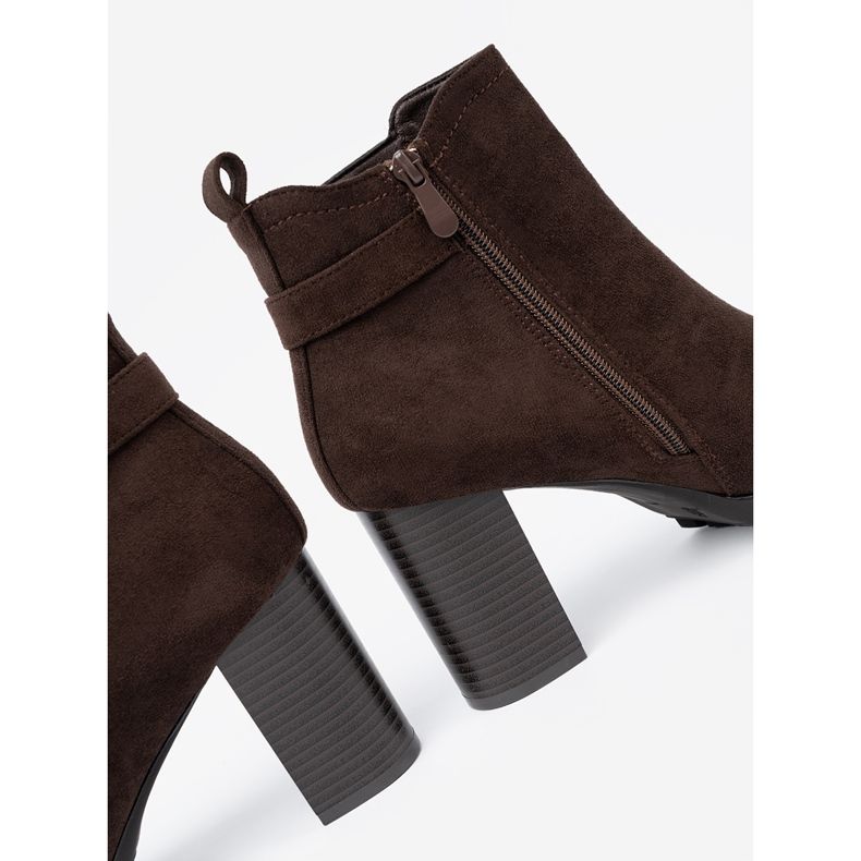 Shelvt Botas marrons escuras no poste com um grampo decorativo 1 Shelvt Botas marrons escuras no poste com um grampo decorativo 1