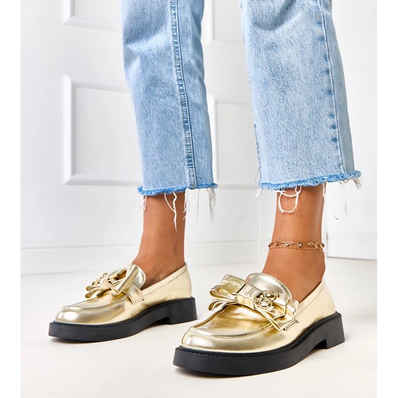 Mocas de ouro com um arco e urso de pelúcia dourado 1