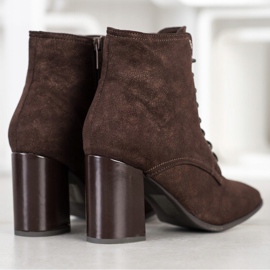 Kylie Botas amarradas em um poste marrom 1