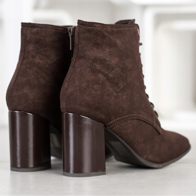 Kylie Botas amarradas em um poste marrom 1