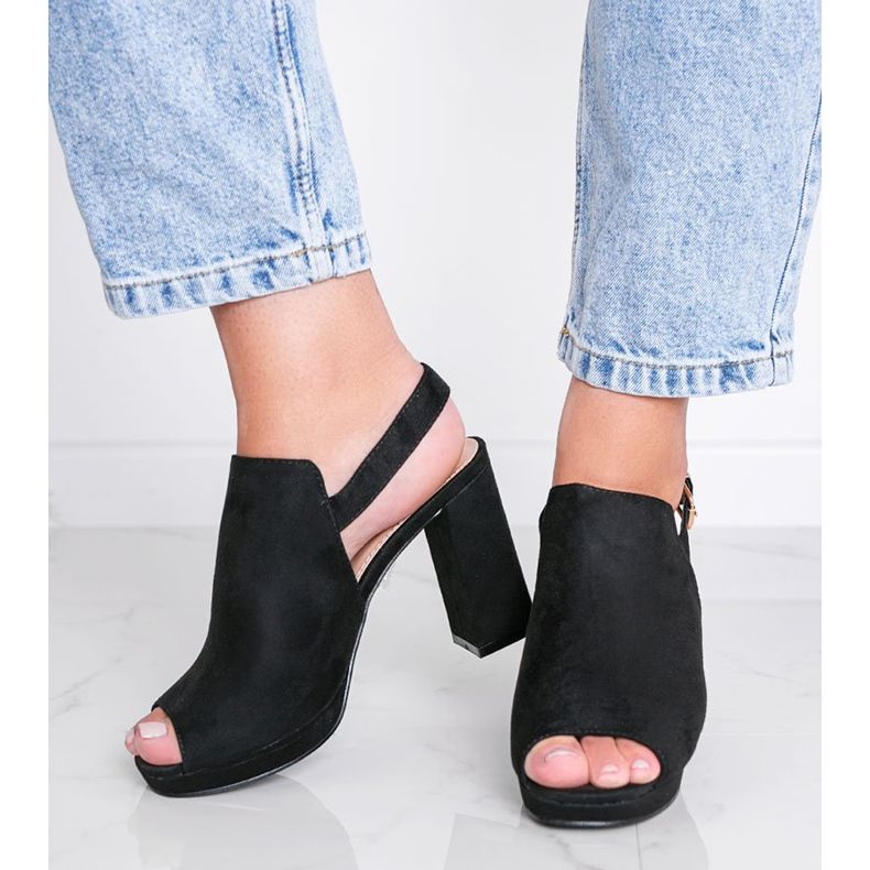 Sandálias pretas em um posto Pimp preto 1