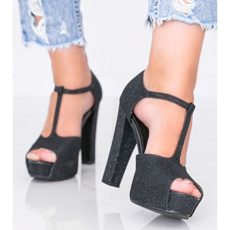 Sapatos pretos brilhantes no posto de Elissa 1