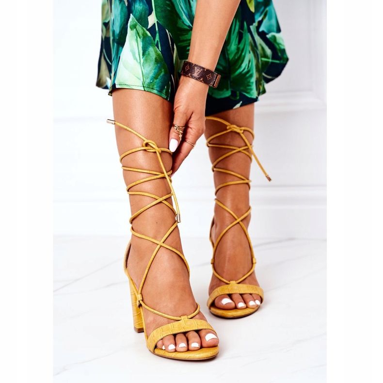 PS1 Sandálias amarradas em uma barra amarela de passarela amarelo 1