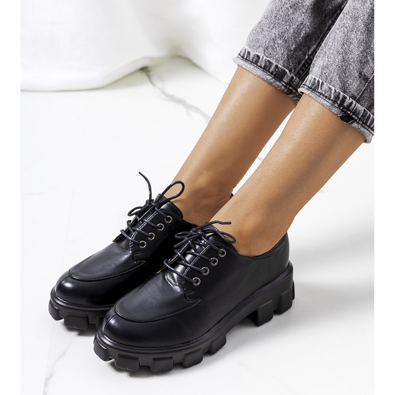 Sapatos pretos em uma sola de trator felina 1 Sapatos pretos em uma sola de trator felina 1