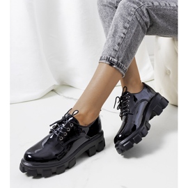 Sapatos lacados pretos em uma sola de trator Vento 1