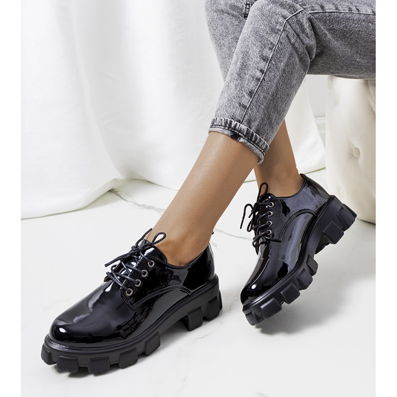 Sapatos lacados pretos em uma sola de trator Vento 1